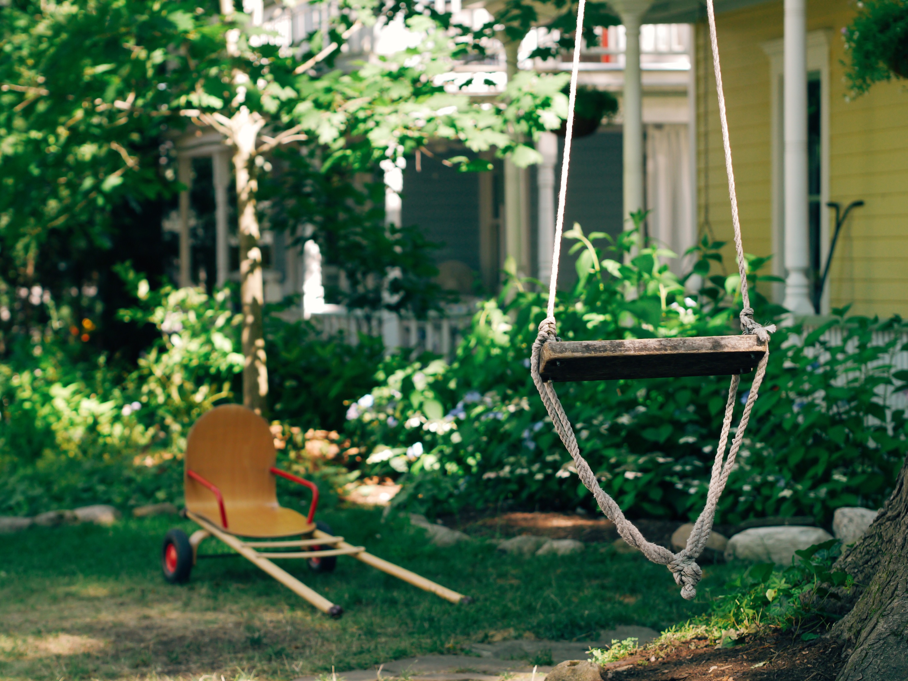 Swing in the foreground of a house.