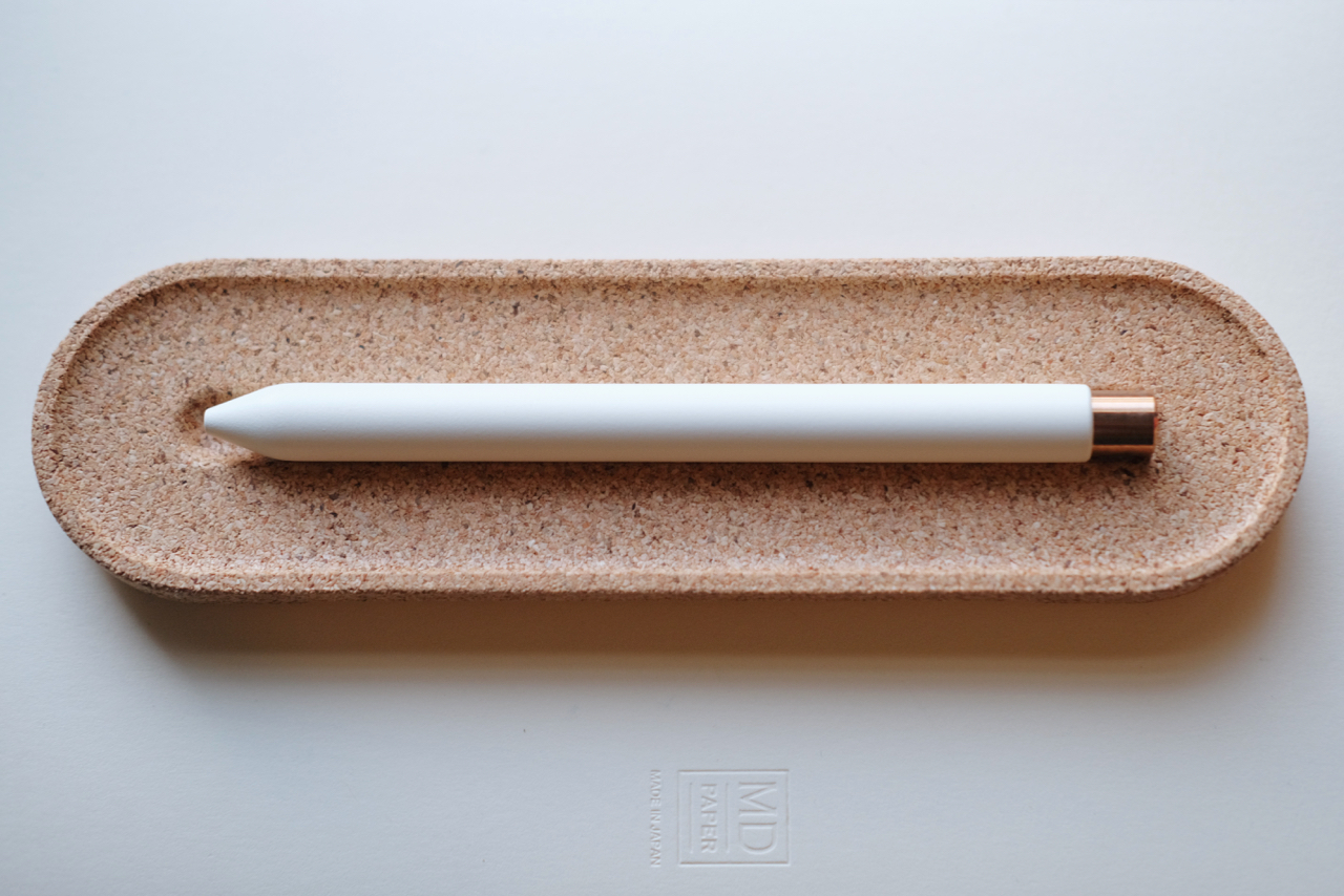 View of white/copper pen in a cork holder.